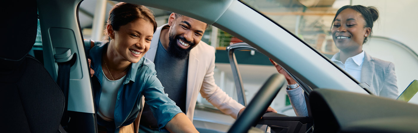 Customers Inspecting Car with Saleswoman